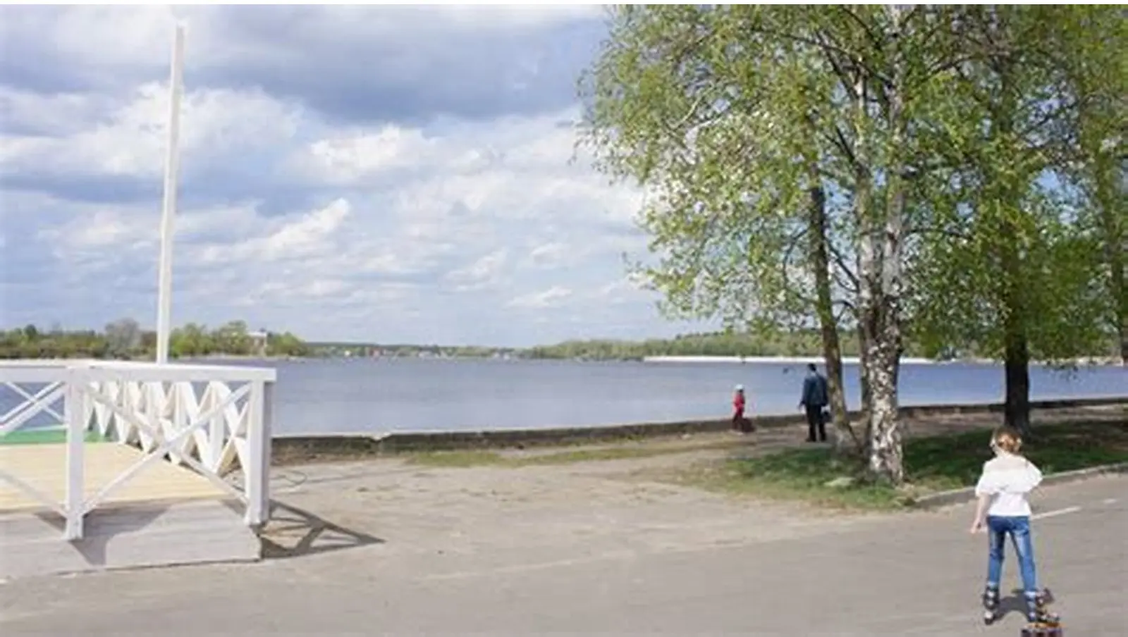 Аллея городского парка у водоёма летом